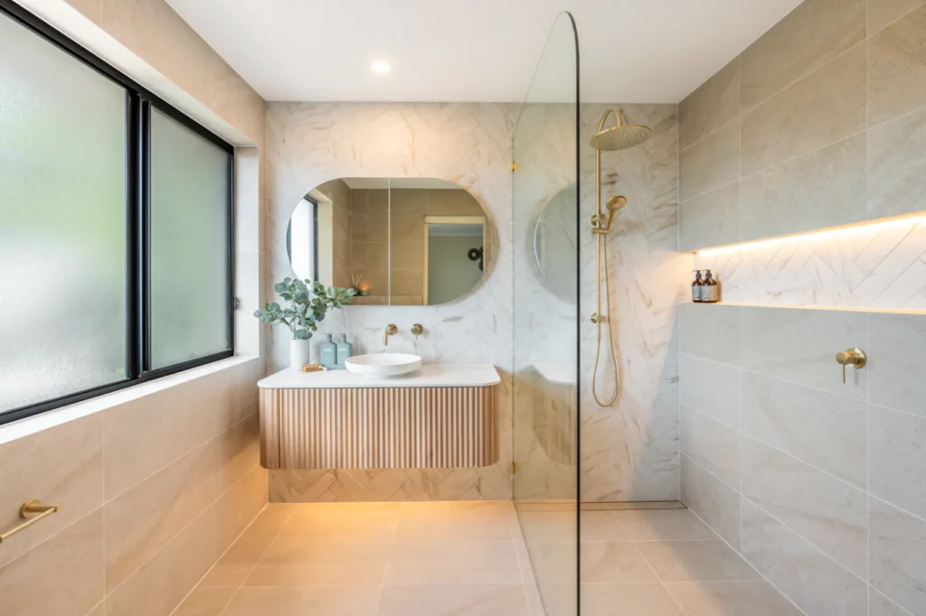 A luxury bathroom renovation in Canberra showing the sink, bathroom mirror, and shower